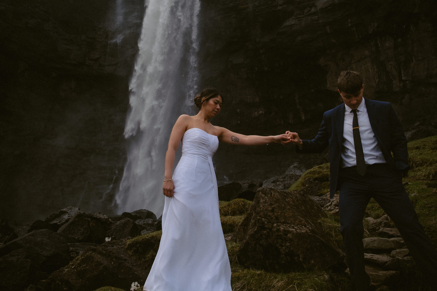 Couple exploring a waterfall in the Faroe Islands on their elopement day