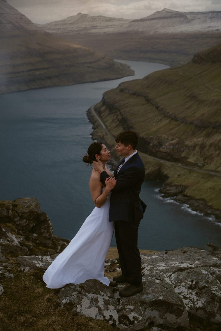 Classic wedding portrait of an elopement couple in the Faroe Islands with a huge fjord in the background